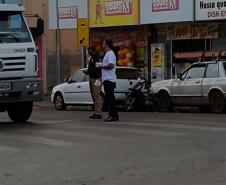 Voluntário e policial militar distribuindo folders para os motoristas